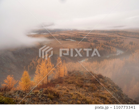 Thick snow clouds float over an autumn wooded mountain valley Thick snow clouds float over an autumn wooded mountain valley 110773341
