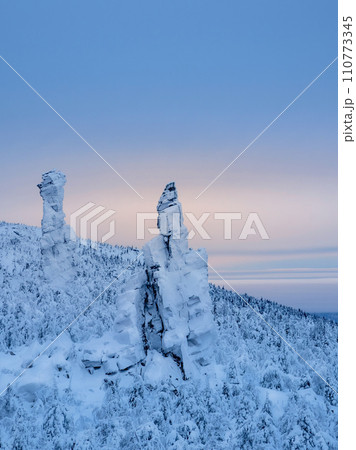 Weathering posts. High stone cliff covered with snow Weathering posts. High stone cliff covered with snow 110773345