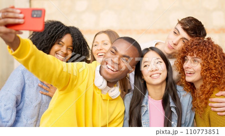 African man taking a selfie with multi-ethnic friends outdoors 110773851
