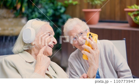 Seniors having fun with the mobile in a nursing home Seniors having fun with the mobile in a nursing home 110773947