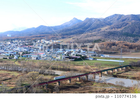 冬枯れの景色のなか空知川橋梁を渡る根室本線の普通列車（後追い） 110774136