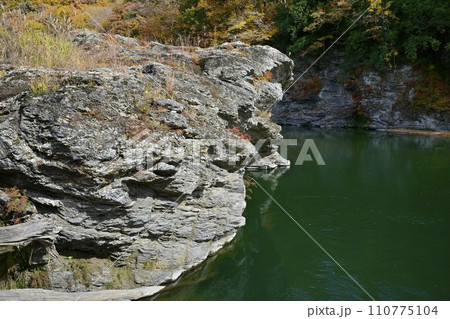 長瀞岩畳南端付近の岩場と荒川の流れに紅葉の渓谷 長瀞岩畳南端付近の岩場と荒川の流れに紅葉の渓谷 110775104