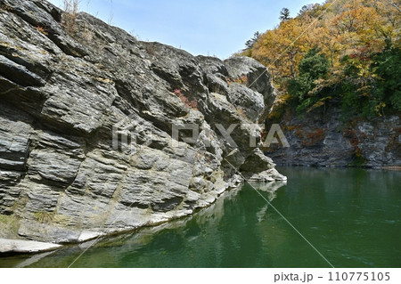 長瀞岩畳南端付近の岩場と荒川の流れに紅葉の渓谷 110775105