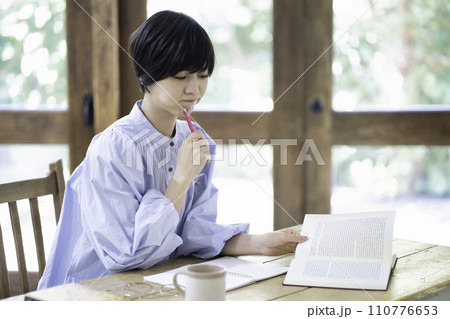 リビングで勉強中に悩む女性 リビングで勉強中に悩む女性 110776653
