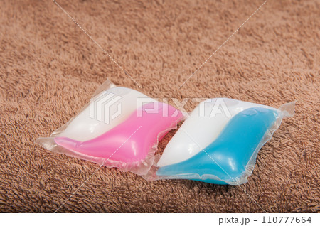 Washing color gel capsule on the brown cloth texture Washing color gel capsule on the brown cloth texture 110777664