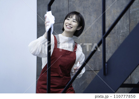 拭き掃除をするエプロンの女性 110777850