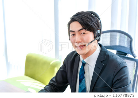 真剣な表情でオンライン会議に参加するビジネスマン 110778975