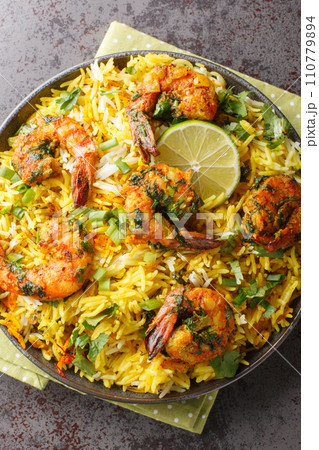Persian style shrimp rice with lots of herbs and spices closeup on the plate. Vertical top view Persian style shrimp rice with lots of herbs and spices closeup on the plate. Vertical top view 110779894
