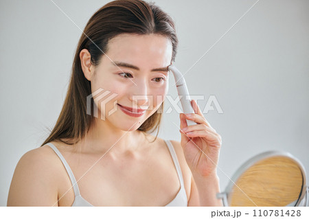 電気シェーバーで顔を剃る30代女性 電気シェーバーで顔を剃る30代女性 110781428