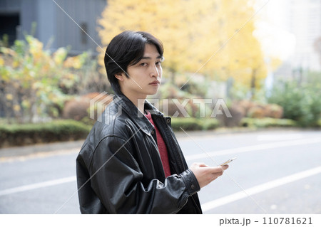 冬の西新宿と革ジャンを着てスマホを持つ若者 冬の西新宿と革ジャンを着てスマホを持つ若者 110781621