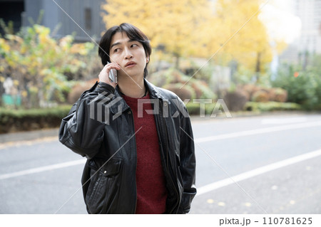 冬の西新宿と革ジャンを着てスマホで話す若者 冬の西新宿と革ジャンを着てスマホで話す若者 110781625