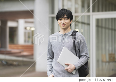 ノートパソコンを持ったカメラ目線の若い男性 大学生イメージ ポートレート ノートパソコンを持ったカメラ目線の若い男性 大学生イメージ ポートレート 110781991