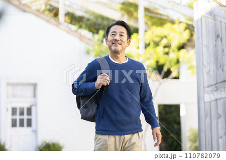 リュックを肩にかけて歩く中年男性  リュックを肩にかけて歩く中年男性  110782079