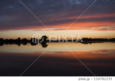 reflection of clouds in lake water during sunset reflection of clouds in lake water during sunset 110782235