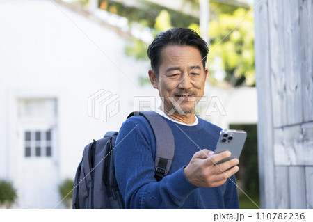 スマートフォンの画面を見る中年男性 110782236