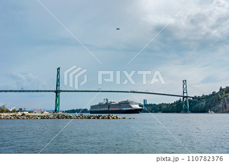 View of ocean harbor with huge ocean cruise liner passing Lion Gates Bridge View of ocean harbor with huge ocean cruise liner passing Lion Gates Bridge 110782376