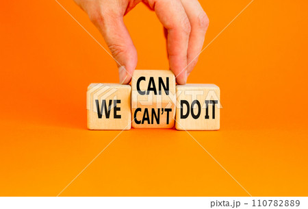 We can do it symbol. Concept word We can or can not do it on beautiful wooden cubes. Beautiful orange table orange background. Businessman hand. Business and we can or not do it concept. Copy space. 110782889