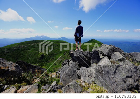 雄阿寒岳山頂から景色を眺める登山者 110783335