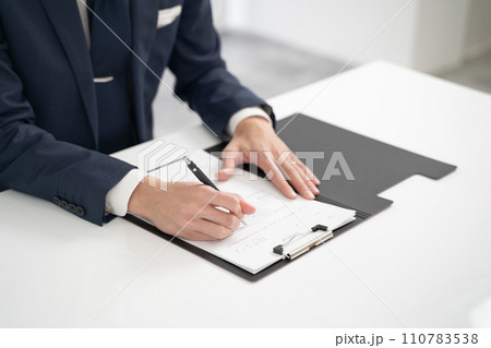 育児休業申請書にサインするビジネスマンの手元 110783538
