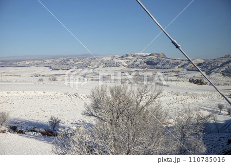 Snow. Winter landscape covered in a white blanket of snow covering mountains and roads. Trees with snow. Clear day. White blanket due to a storm with heavy snowfall. In Spain. January. 2024. Snow. Winter landscape covered in a white blanket of snow covering mountains and roads. Trees with snow. Clear day. White blanket due to a storm with heavy snowfall. In Spain. January. 2024. 110785016