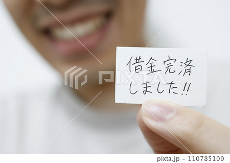 借金完済しましたと書かれた紙を持つ男性 110785109