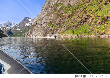 A speed boat navigates Trollfjorden, showcasing the stark beauty of Lofoten A speed boat navigates Trollfjorden, showcasing the stark beauty of Lofoten 110785300