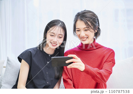 スマートフォンの画面を見ている女性達 110787538