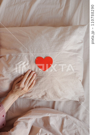 women's hands holding red heart shaped postcard, surprise gift for Valentine's day. 110788290