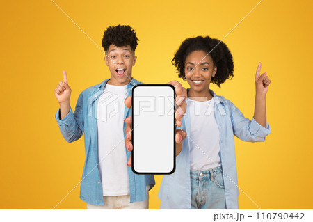 Excited young woman and man presenting a blank smartphone screen with room for text 110790442