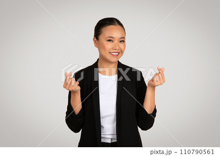 Optimistic Asian businesswoman in a black blazer making a wishful fingers crossed gesture with a hopeful smile Optimistic Asian businesswoman in a black blazer making a wishful fingers crossed gesture with a hopeful smile 110790561