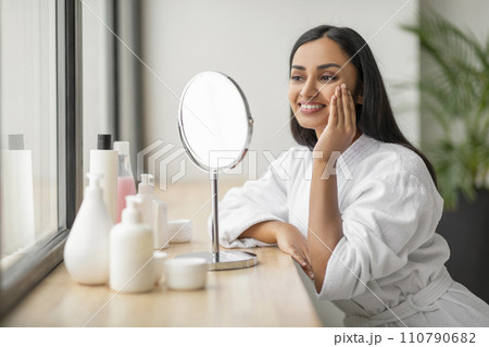 Beautiful young indian woman looking at mirror 110790682