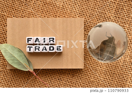 FAIR TRADEの語にワードビーズが並んでいる脇にガラスボールの地球がある FAIR TRADEの語にワードビーズが並んでいる脇にガラスボールの地球がある 110790933