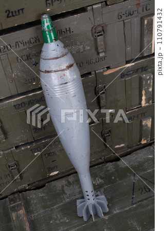 120 mm mortar shell on army green crate. Text in russian - type of ammunition, projectile caliber, projectile type, number of pieces and weight. 120 mm mortar shell on army green crate. Text in russian - type of ammunition, projectile caliber, projectile type, number of pieces and weight. 110791432