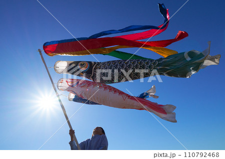 青空のもと鯉のぼりを見上げる少年 110792468