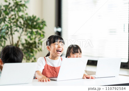 プログラミング学習をしている小学生と先生。 110792584