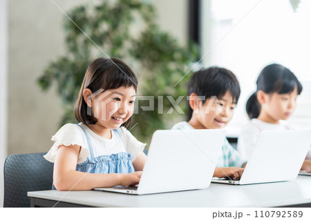 プログラミング学習をしている小学生と先生。 110792589