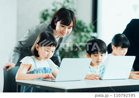 プログラミング学習をしている小学生と先生。 プログラミング学習をしている小学生と先生。 110792595