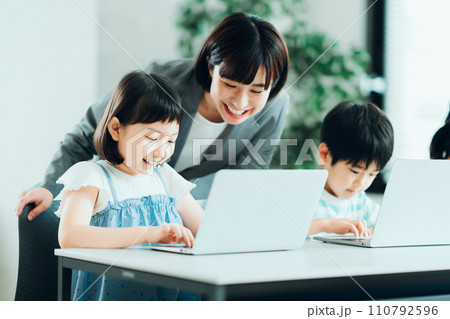 プログラミング学習をしている小学生と先生。 110792596