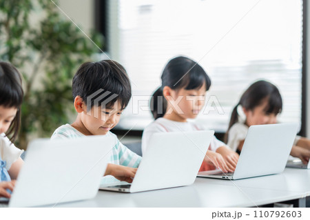 プログラミング学習をしている小学生と先生。 110792603