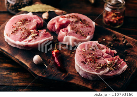Pork loin steaks with ground spices on cutting board Pork loin steaks with ground spices on cutting board 110793160