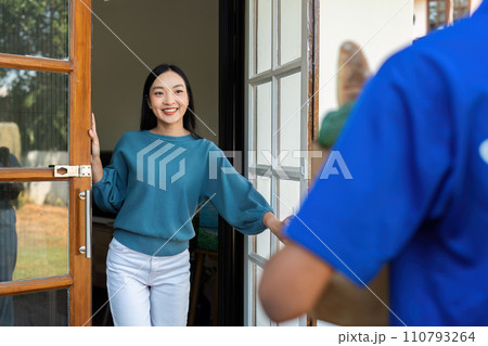 Asian young delivery man delivering package to female customer at home 110793264