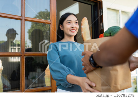 Asian young delivery man delivering package to female customer at home 110793279