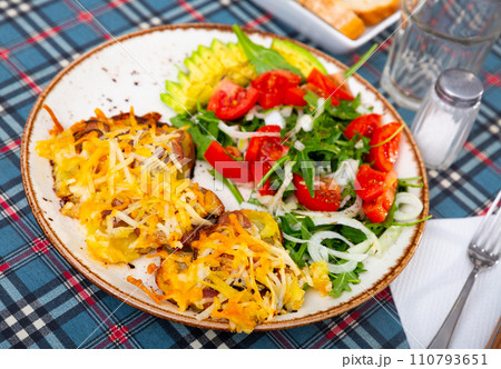 Veal Orloff served with baked potato and vegetable salad 110793651