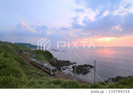 信越本線と日本海の夕日 110794258