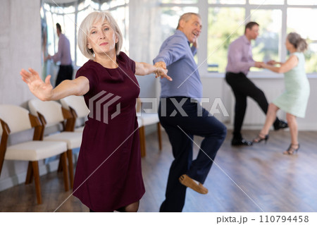 Beautiful mature woman in dance salon studying with her partner to dance couples ballroom dance paso doble 110794458