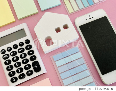 電卓・スマホ・付箋に囲まれた白い家の模型 電卓・スマホ・付箋に囲まれた白い家の模型 110795610