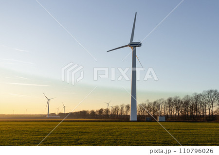 Aerial view of powerful Wind turbine farm for energy production on beautiful cloudy sky at highland. Wind power turbines generating clean renewable energy for sustainable development. 4k footage. Aerial view of powerful Wind turbine farm for energy production on beautiful cloudy sky at highland. Wind power turbines generating clean renewable energy for sustainable development. 4k footage. 110796026