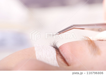 つけまつ毛を接着してもらっている若い女性 110796806