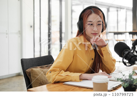 Female podcaster making audio podcast from her home studio 110799725