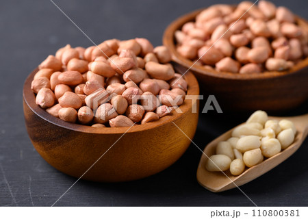 Peanut in wooden bowl with spoon on black background Peanut in wooden bowl with spoon on black background 110800381